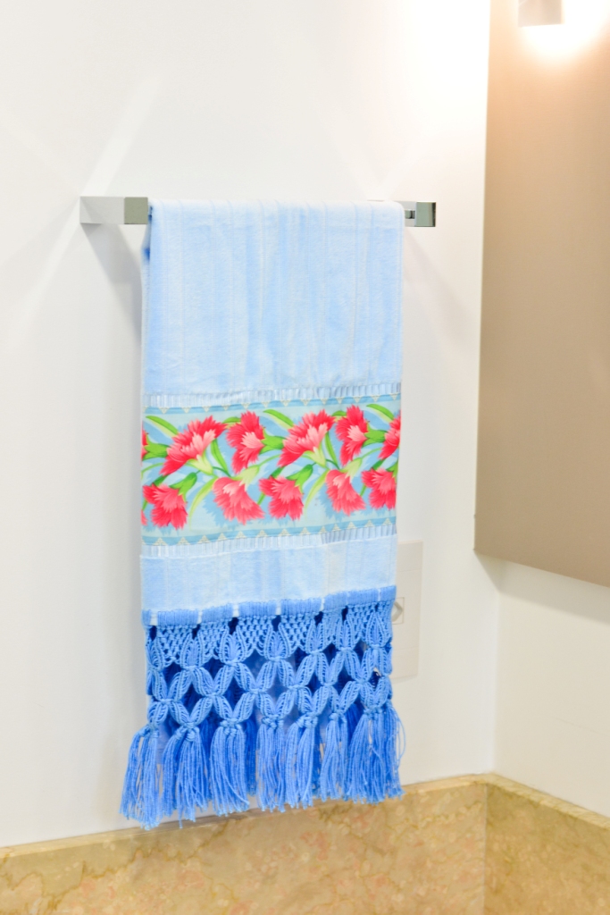 toalha azul com flores e ponta em macramê